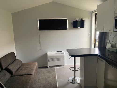 a kitchen with a couch and a table in a room at Christchurch Airport Tiny House in Christchurch