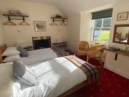 a bedroom with two beds and a fireplace at The Gordon Arms Restaurant with Rooms in Yarrow