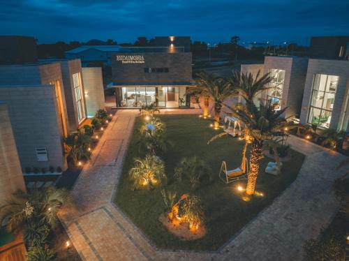 an aerial view of a building with a courtyard with palm trees at Eudaimonia Poolvilla Jeju 에다모니아 함덕풀빌라 in Jeju