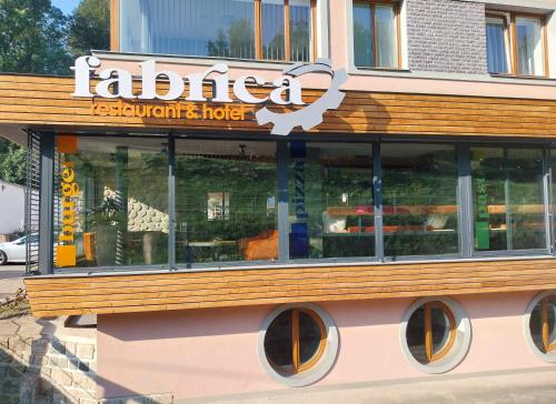 a restaurant with a sign on the side of a building at Hotel Fabrica in Liberec
