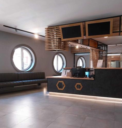 a lobby with a bar with a couch and windows at Hotel Fabrica in Liberec