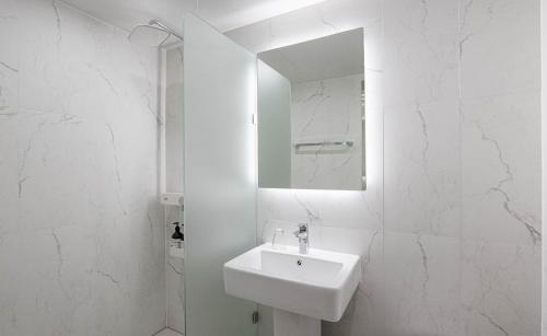 a white bathroom with a sink and a mirror at Star light Hotel in Seoul