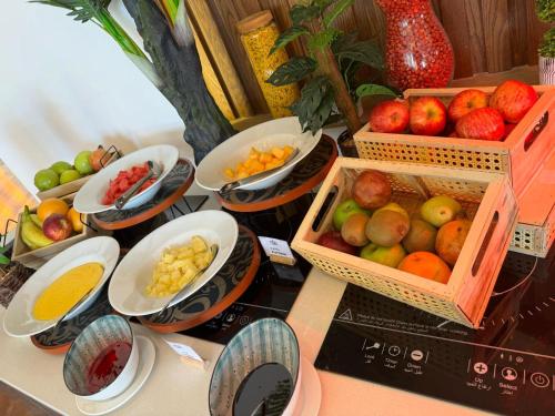 een tafel met manden met groenten en fruit bij Dragon Beach Hotel in Manamah