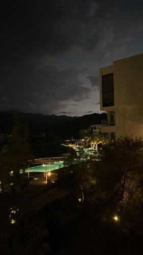 a night view of a building and a swimming pool at 2BHK furnished flat with jacuzzi in As Sīfah