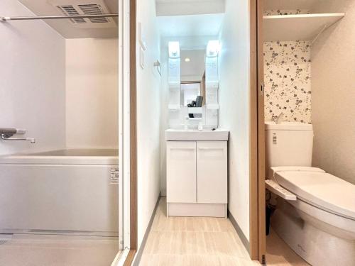 a bathroom with a toilet and a tub and a sink at Shinjuku-STS Hostel in Tokyo