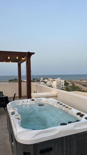 a hot tub on a patio with a view of the ocean at 2BHK furnished flat with jacuzzi in As Sīfah