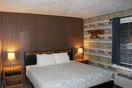 a bedroom with a bed and two lamps and a window at Cedarwood Inn of Ashland in Ashland