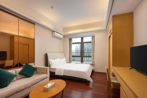 Una sala de estar con un sofá y un televisor. en 伊莲萨维尔酒店, en Guangzhou