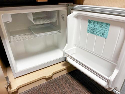 an empty refrigerator with its door open in a room at Hotel Route Inn Toyama Inter in Toyama