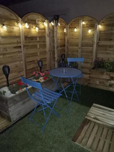 - une table et des chaises dans une chambre dotée de murs en bois dans l'établissement Hébergement L'extension Bien-être, à Goux-les-Usiers