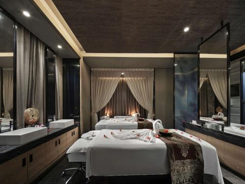 a room with two beds and a bathroom with two sinks at Hilton Shenzhen Shekou Nanhai in Shenzhen