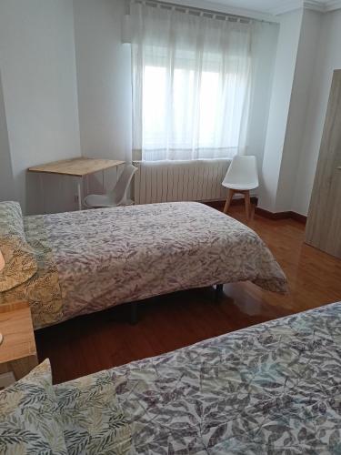 a hotel room with two beds and a window at Piso Turístico Arévalo in Arévalo