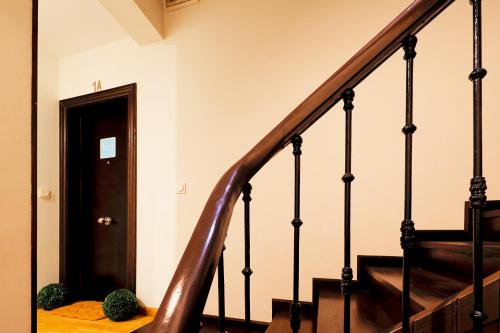 a hallway with stairs and a door with two plants at Dúplex Casco Histórico-Catedral Parking incluido in Oviedo