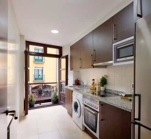 a kitchen with a washer and dryer at Dúplex Casco Histórico-Catedral Parking incluido in Oviedo