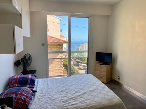 une chambre avec un lit et une grande fenêtre dans l'établissement Studio Monaco central - wifi, à Beausoleil