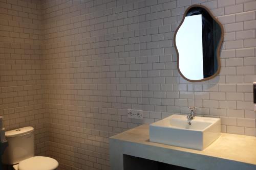a bathroom with a sink and a mirror on the wall at Dipenida Bali in Sampalan