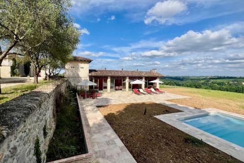 une vue extérieure d'une maison avec piscine dans l'établissement Château 14e siècle vue panoramique sur les vignes, à Le Tourne