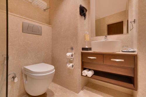 a bathroom with a toilet and a sink at Lemon Tree Hotel, Noida in Noida