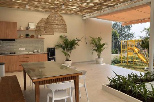 une cuisine et une salle à manger avec une table et des chaises dans l'établissement Cottonwood Villa Samani Pool HOT-Jacuzzi Billyard, à Bandung