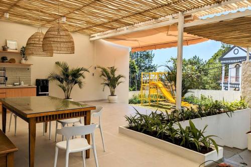 une cuisine avec une table et des chaises ainsi qu'une aire de jeux dans l'établissement Cottonwood Villa Samani Pool HOT-Jacuzzi Billyard, à Bandung