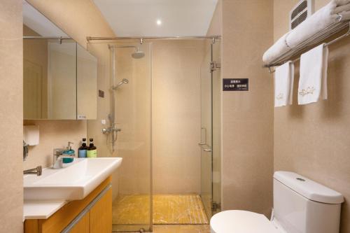 Un baño con ducha, inodoro y lavabo. en 伊莲萨维尔酒店, en Guangzhou