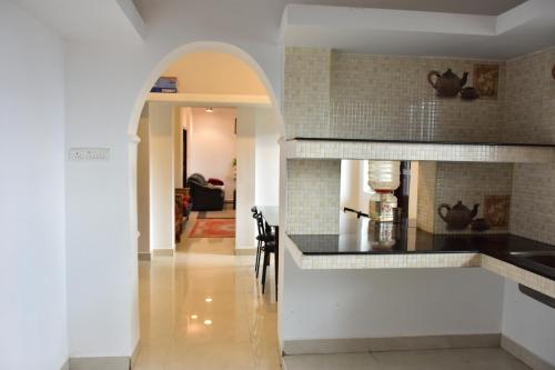 a kitchen with an archway leading into a living room at Naturehunt homestays in Kodaikānāl
