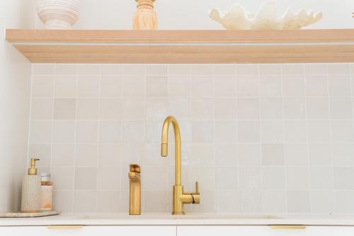 a kitchen counter with a sink and a faucet at La Casa Byron in Byron Bay