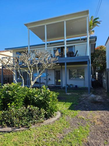 a house with a blue and white at Surfs Up! Oceanfront Home Sleeps 6 steps from the sand in Emerald Beach