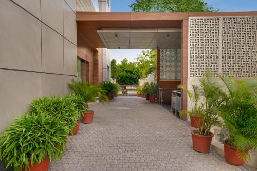 a courtyard with potted plants on the side of a building at Lemon Tree Hotel, Noida in Noida