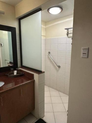 a bathroom with a sink and a shower with a mirror at Alta Vista De Boracay, Loft 304 in Boracay