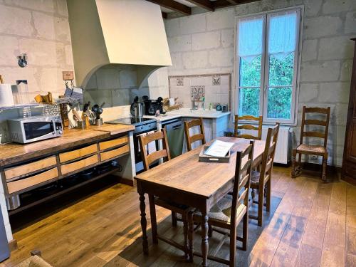 - une cuisine avec une table et des chaises en bois dans l'établissement Gîte de Parnay, à Parnay