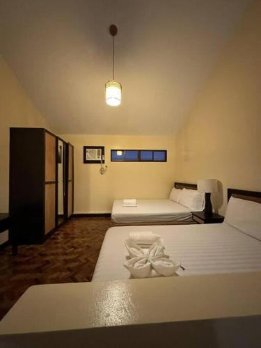 a hotel room with two beds and a lamp at Alta Vista De Boracay, Loft 304 in Boracay