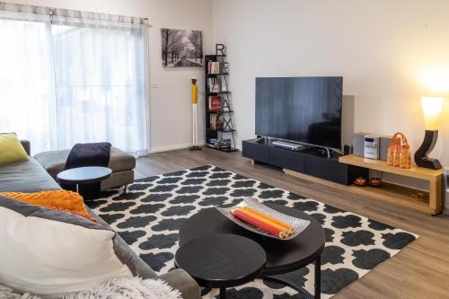 a living room with a couch and a tv at Wotama, Macedon B and B, Honour Ave, Mount Macedon in Mount Macedon