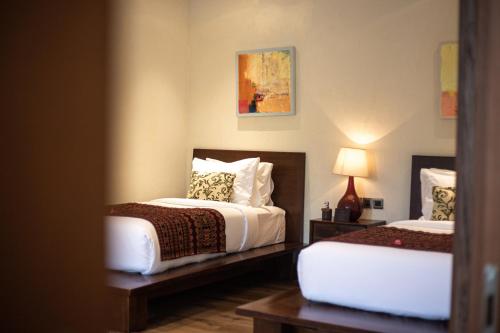 a hotel room with two beds and a mirror at Plataran Komodo Resort & Spa - CHSE Certified in Labuan Bajo