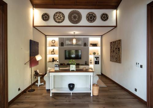 a living room with a white table and a tv at Plataran Komodo Resort & Spa - CHSE Certified in Labuan Bajo