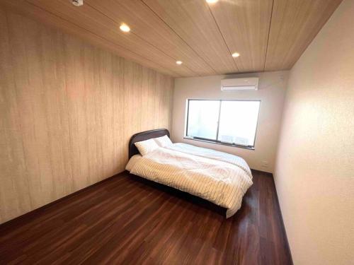 a small bedroom with a bed and a window at 松林阁 in Osaka