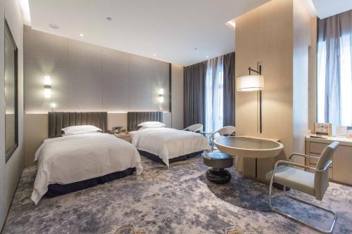a hotel room with two beds and a sink at Chongqing Liyuan Hotel in Chongqing