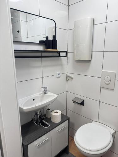 a white bathroom with a toilet and a sink at MaRu Living M71 in Cologne
