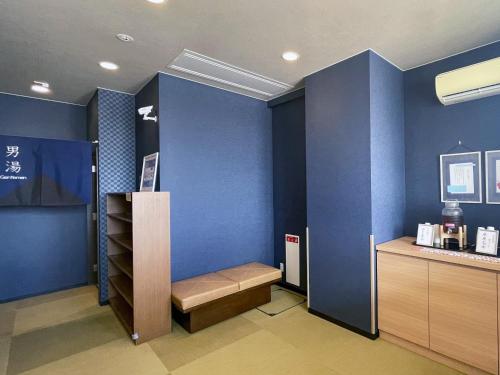 a room with a blue wall with a bench and a shelf at Route Inn Grantia Himi Wakuranoyado in Himi