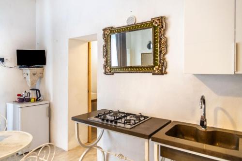 kuchnia ze zlewem i lustrem na ścianie w obiekcie Monolocale con bagno, angolo cottura e letto matrimoniale a Baldacchino w mieście Monterotondo