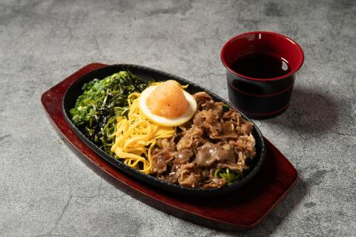 a black dish of food with pasta and a lemon slice at ホテル ブルジュア 久留米 Hotel Bvljua -レジャーホテル- in Kurume