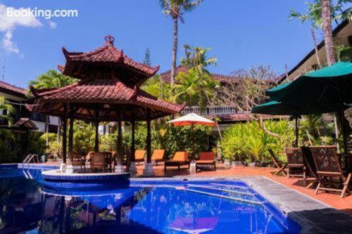 a swimming pool with a gazebo and a swimming pool at Sarinande Hotel in Seminyak