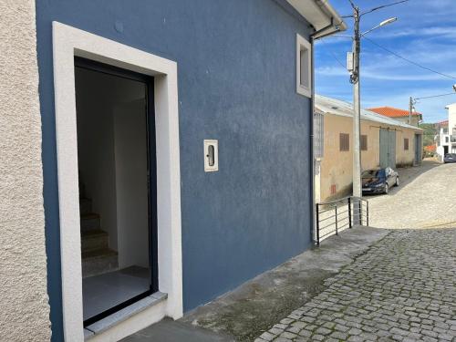a blue building with a large door on a street at Casa da Calabra by Trip2Portugal in Cedovim