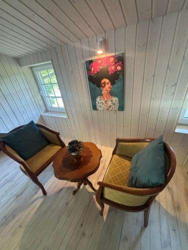 a room with a couch and a table in a room at Cozy studio in a horse ranch in Lieplaukė
