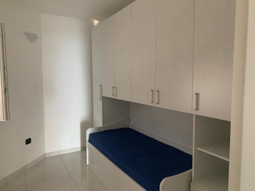 a small room with white cabinets and a blue bed at VILLA ARCANGELO Le in Mandatoriccio Marina