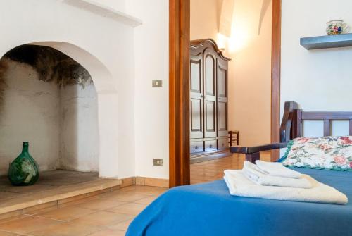 een slaapkamer met een blauw bed en een open haard bij Tenuta Badessa in Casalabate