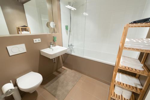 a bathroom with a toilet and a sink and a shower at Premium Apartments Thommen in Nürnberg