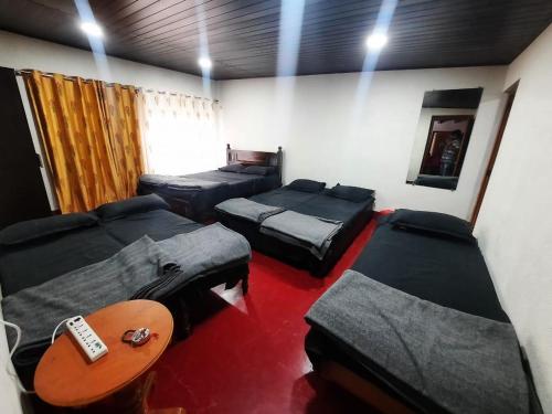 奇克马格尔Vintage Retreat 1970's的一间设有四张床、一张沙发和一张桌子的房间