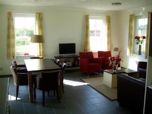 a living room with a couch and a table at Emslander Comfort 6-Speciaal 43 in Vlagtwedde