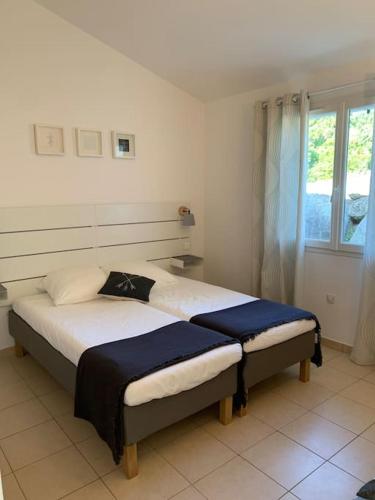 une chambre avec deux lits et une fenêtre dans l'établissement Villa Caroline - Maison dans belle résidence avec piscine - Sainte Lucie de Porto Vecchio, à Sainte-Lucie de Porto-Vecchio